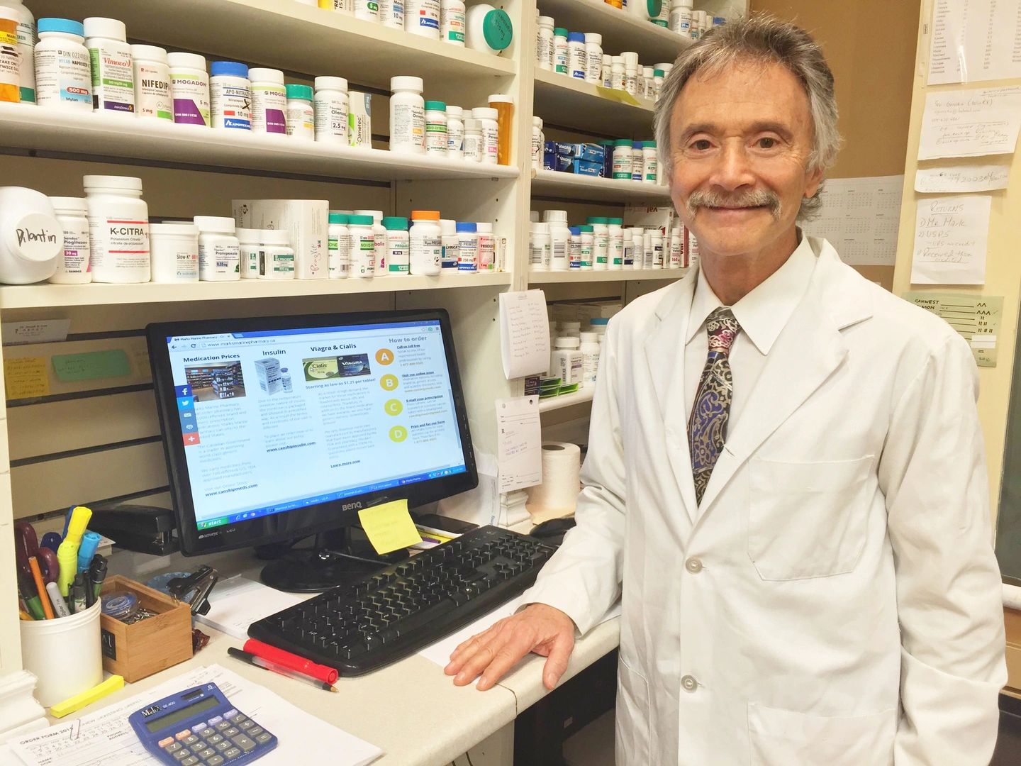 A licensed pharmacist in a white coat in the Marks Marine Pharmacy dispensary.